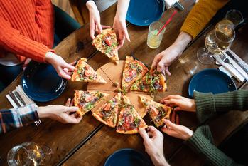 Is It Time to Buy Domino's Stock?: https://g.foolcdn.com/editorial/images/741227/taking-slices-of-pizza-from-the-wooden-board-in-a-restaurant.jpg