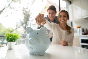 2 Dividend Raises That Can Boost Your Passive Income: https://g.foolcdn.com/editorial/images/702545/couple-in-a-kitchen-placing-coins-into-a-piggy-bank.jpg