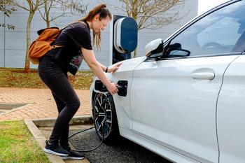 The Disconnect Between Tesla's Business and Stock Price Continues to Grow Wider: https://g.foolcdn.com/editorial/images/687659/woman-near-the-electric-refueling-station-carrying-her-car.jpg