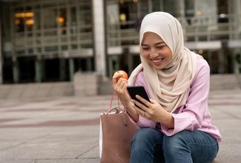 If You'd Invested $1,000 in Apple in 2000, This Is How Much You'd Have Today: https://g.foolcdn.com/editorial/images/741496/woman-hijabi-eating-apple-on-phone-online-banking.jpg