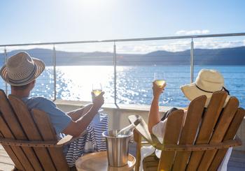 Why Are Investors So Excited About Carnival Stock?: https://g.foolcdn.com/editorial/images/736192/couple-relaxing-and-drinking-wine-on-deck-chairs-in-an-over-water-bungalow.jpg