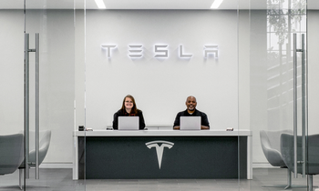 Elon Musk Is "Uncomfortable Growing Tesla to Be a Leader in AI and Robotics" Without This 1 Key Development Happening: https://g.foolcdn.com/editorial/images/761471/tesla-service-center-with-two-associates-at-desk-with-tesla-logo.png