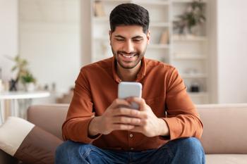 8 Ways the Secure Act 2.0 Helps You Save for Retirement: https://g.foolcdn.com/editorial/images/715339/investor-smiling-phone-at-home.jpg