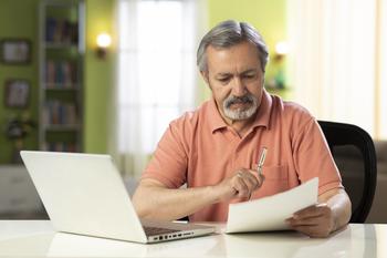 When Is It OK to Tap Your Retirement Savings?: https://g.foolcdn.com/editorial/images/721833/mature-person-holding-pen-and-looking-at-document.jpg