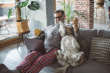 E-Commerce Giant Chewy Is Opening Physical Spaces -- but They're Not What You Might Expect: https://g.foolcdn.com/editorial/images/770145/person-sits-on-couch-with-dog-coffee-and-computer.jpg