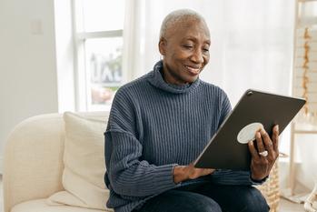 Is the S&P 500 All You Need to Retire a Millionaire?: https://g.foolcdn.com/editorial/images/701156/older-person-sitting-on-a-couch-looking-at-a-tablet.jpg