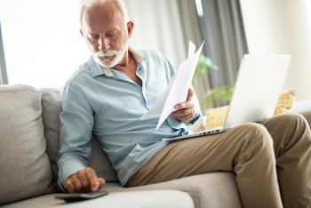 3 Hidden Threats to Your Retirement You Need to Prepare For: https://g.foolcdn.com/editorial/images/845562/senior-man-couch-docs-calc-laptop-gettyimages-1343962734.jpg