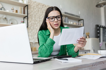Need to Cut Back on Retirement Savings This Year? At Least Aim to Do This.: https://g.foolcdn.com/editorial/images/853423/woman-20s-at-desk-holding-doc-gettyimages-1501133456.jpg