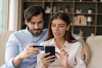 The Newest Member of the $1 Trillion Club Has Soared 4,755,356% Since Its IPO, and It's Still a Buy Right Now, According to Wall Street (Hint: Not a Tech Stock): https://g.foolcdn.com/editorial/images/854540/a-young-couple-keying-credit-card-information-into-a-smartphone-screen.jpg