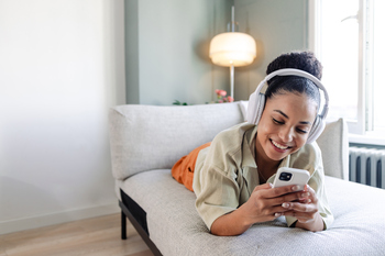 Why Ciena Stock Rocked the Market on Monday: https://g.foolcdn.com/editorial/images/862052/happy-person-using-headphones-and-a-phone-while-lying-on-a-couch.jpg