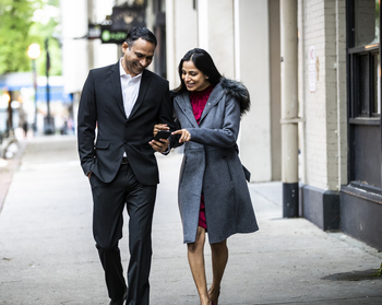 Should You Buy Apple Stock Before June 8?: https://g.foolcdn.com/editorial/images/869364/a-couple-walking-and-looking-at-a-cell-phone.jpg