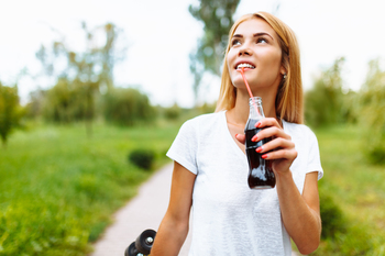 2 Warren Buffett Dividend Stocks to Buy With $1,000: https://g.foolcdn.com/editorial/images/857966/person-drinking-bottled-drink-with-a-straw.jpg